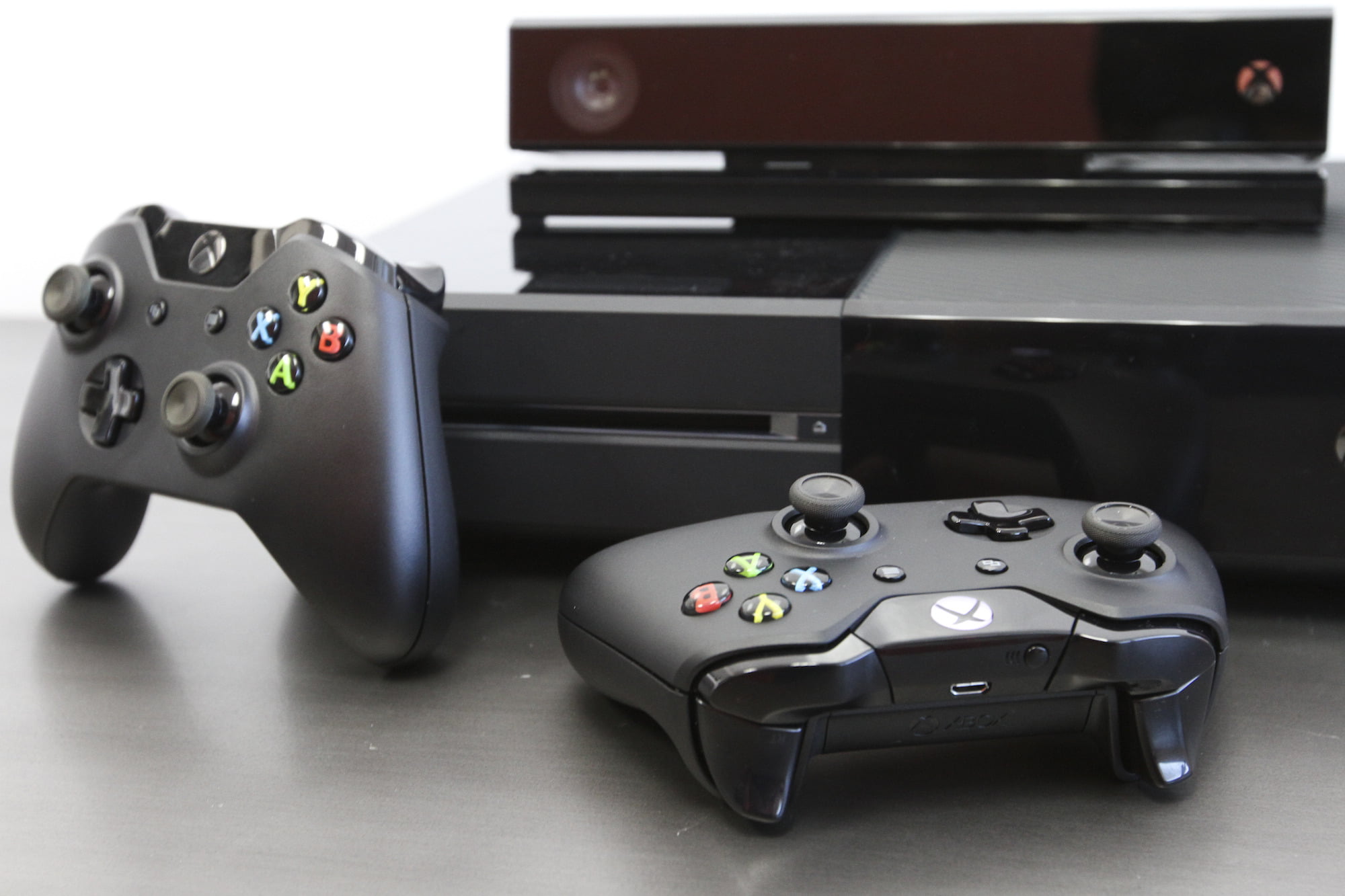 Imagen de la Xbox One negra con Kinect junto a dos mandos